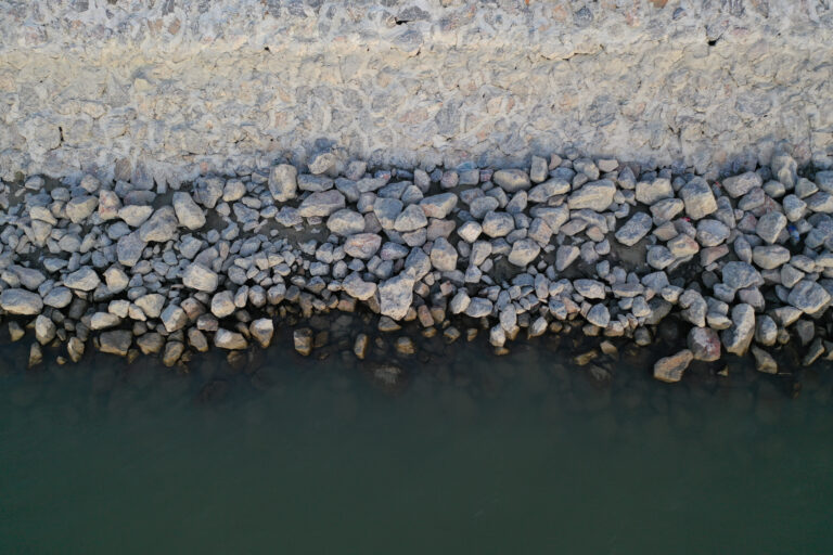 Steinpackung am Ufer eines Flusses.